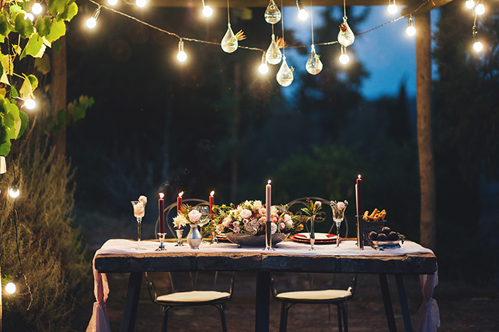 outdoor dining space with fairy lights set for two people