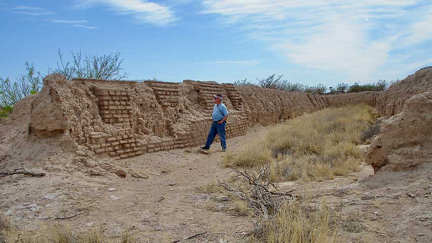 A visitor strolls among the ruins of Fort Craig.