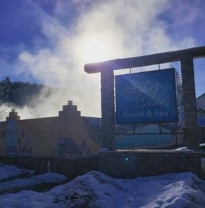 Mist rising behind sing for Healing Waters resort.