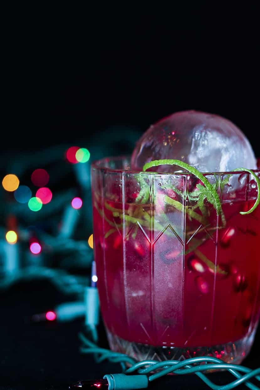 Red cocktail with holiday lights
