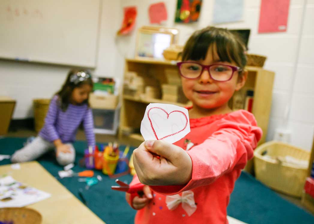 Girl holding heart drawing