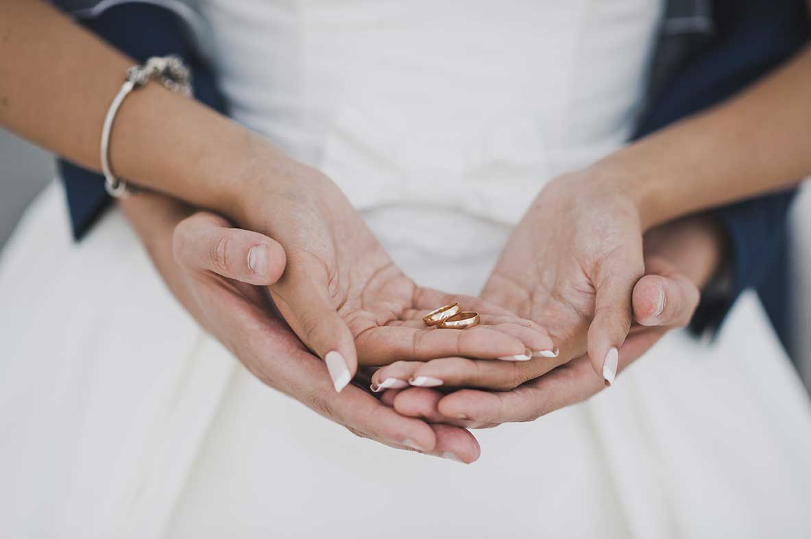 Bride and groom's hands with ring representing a wedding in Santa Fe.