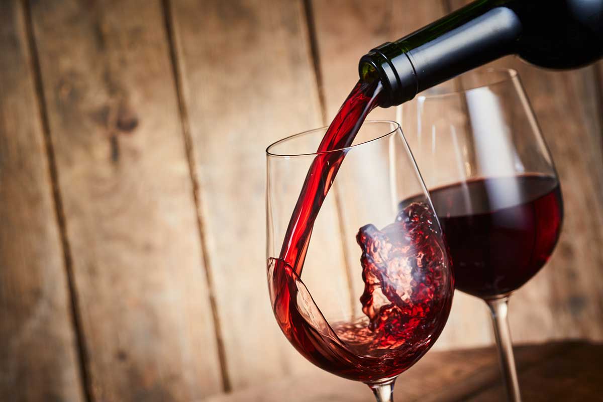 Red wine being poured into a glass.